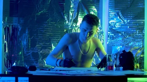 The guy sits down at the table and draws a sketch of the picture. 库存影片 123573943