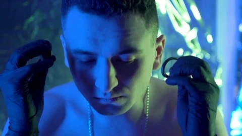 The guy sits down at the table and puts headphones in his ears. Vidéo 123574905