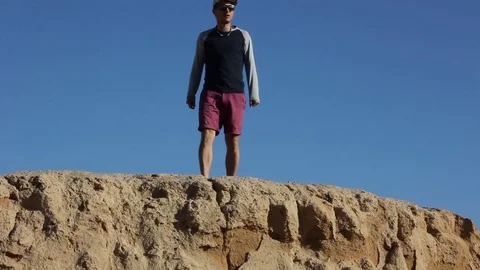 The guy sits on the edge of the cliff Stock Footage 82453693