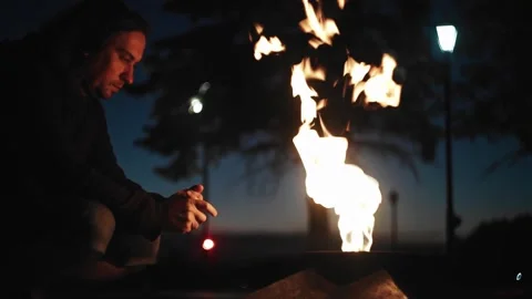 The guy sits in front of the eternal fire and looks at it. Side View Stock Footage 133321827