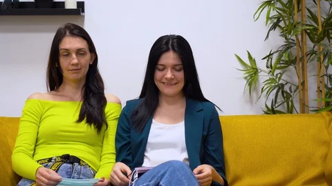 Guy sits on sofa to two young beautiful girls. People stay home and enjoy life  Stock Footage 127788997