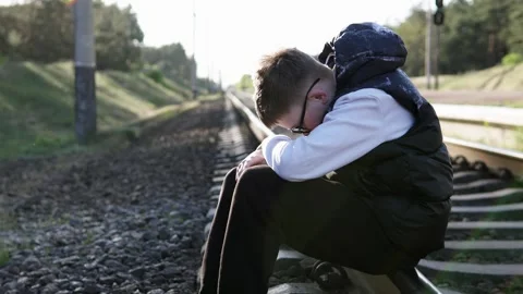 A guy sits on the train tracks after school, depressed. Stock-Footage 332857548