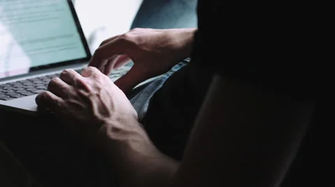 Guy sits on the windowsill and running on the laptop on his lap. Stock Footage 68409289