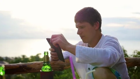 The guy sitting at the bar and typing sms in the cell. Panoramic vew Vidéo 75052675