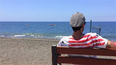 Guy sitting bench beach Stock-Footage 50554859