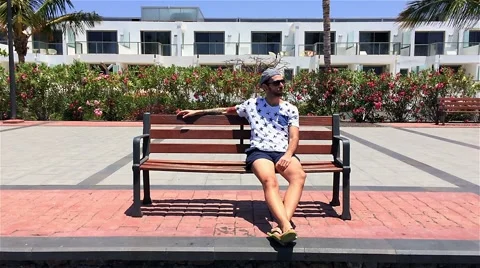 Guy sitting on bench at the beach 動画素材 50626416