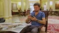 Guy sitting in chair in lobby of hotel, planning his sightseeing route for day HD Footage