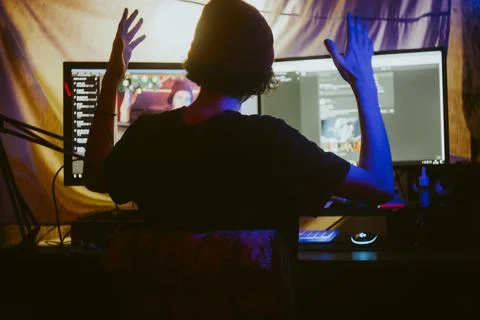 Guy sitting at the computer holding his hands up Stock Photos