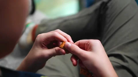 The guy is sitting on the couch and holding a measuring tape in his hands Stock Footage 144540800
