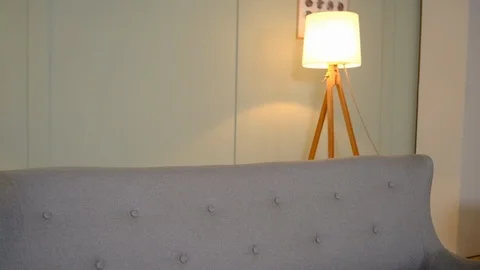 The guy is sitting on the couch and playing on the smartphone Vidéo 126898726