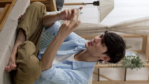 Guy sitting cross legged on sofa cushion Stock Footage 219397723