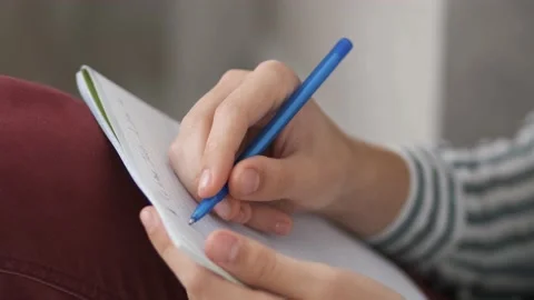 The guy is sitting on the floor and writing notes in a notebook. Ideas. Stock Footage 140920742