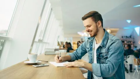 Guy is sitting in front of the table near window Stock Photos