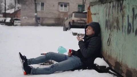 The guy is sitting on the ground and blowing soap bubbles. Winter on the street Stock Footage 123793290