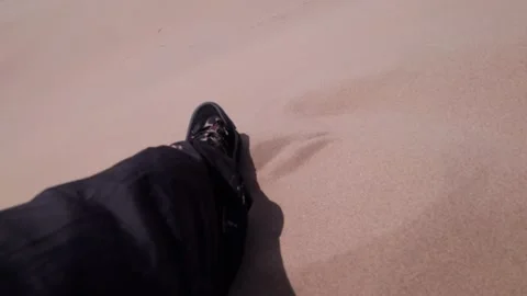 The guy is sitting on a huge sand dune. Leg view Video stock 250168291