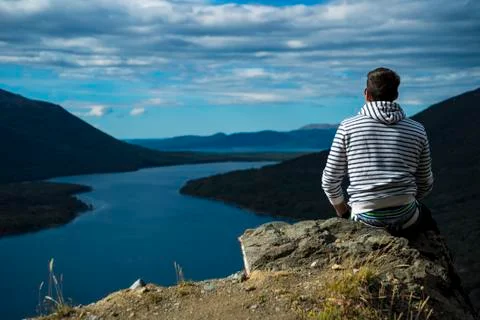 Guy sitting on the ledge of a cliff Stock Photos