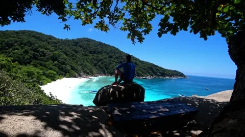 The guy is sitting on a rock and looking at lagoon Stock Footage 191561010
