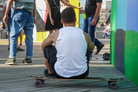 The guy is sitting on the skateboard Stock Photos