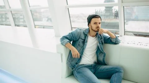 Guy is sitting on sofa and thinking Stock Photos