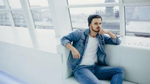 Guy is sitting on sofa and thinking Stock Photos