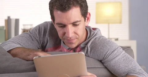 Guy sitting on sofa and using tablet Video stock 42585414