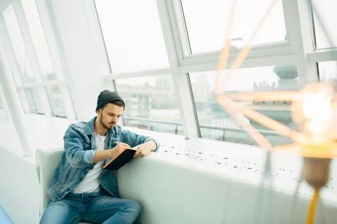 Guy is sitting on sofa and writing notes Stock Photos
