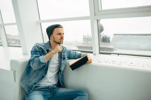 Guy is sitting on sofa and writing notes Stock Photos