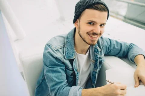 Guy is sitting on sofa and writing notes Stock Photos