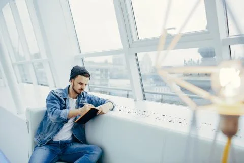 Guy is sitting on sofa and writing notes Foto stock