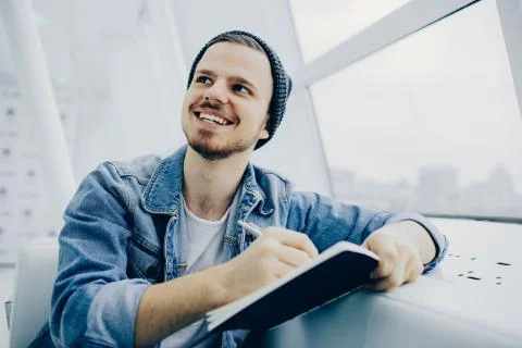 Guy is sitting on sofa and writing notes Stock Photos