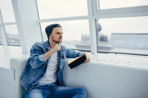 Guy is sitting on sofa and writing notes Stock Photos