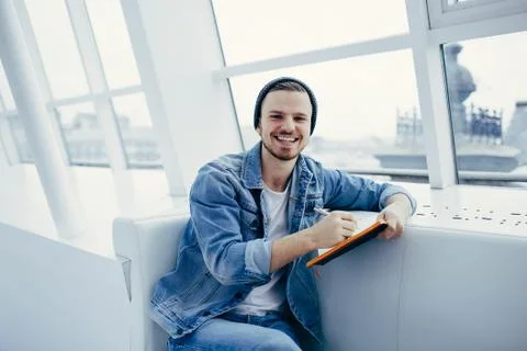 Guy is sitting on sofa and writing notes Stock Photos