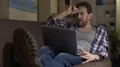Guy sitting on sofa, looking at laptop, angry with received news, bitterness HD Footage