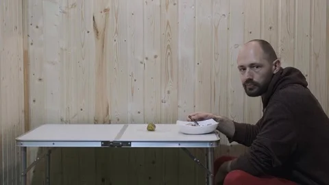 The guy sitting at the table gives a thumbs up and continues to eat Stock Footage 119705058