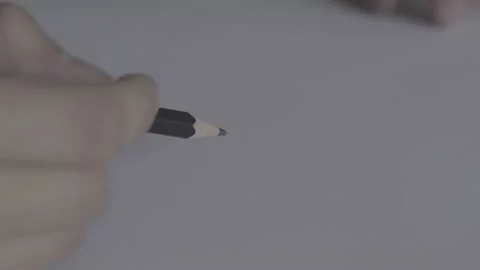 The guy is sitting at the table by the laptop. The guy writes, draws. Stock Footage 130219360