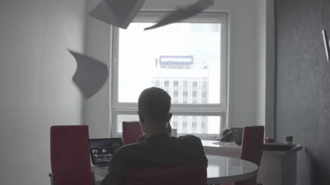 The guy is sitting at the table by the laptop. The guy writes, draws. 動画素材 130229020