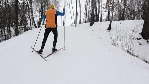 Guy skier climbs a snow-capped mountain Stock Footage 86009895
