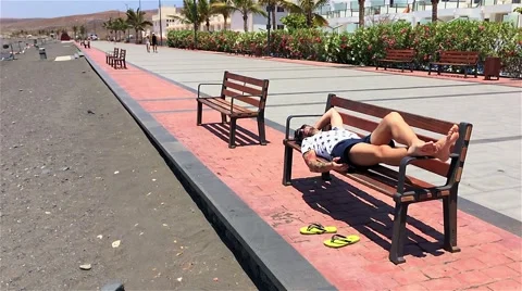Guy sleeping on bench Stock Footage 50628807