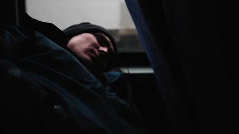The guy is sleeping by the window on the bus lying on the seat. Side view. Stock Footage 142739689