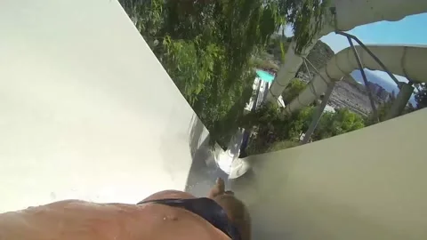 The guy slides down the slide in the water park Stock Footage 154463515