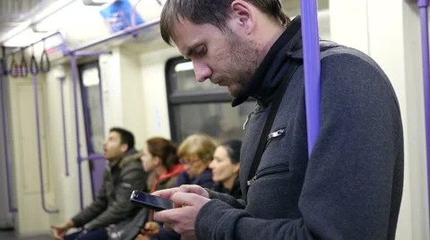 Guy sliding typing smartphone display in subway metro train Stock Footage 57382967