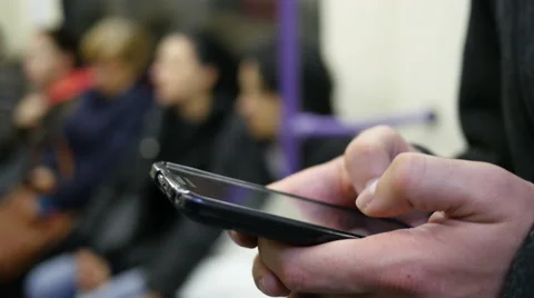 Guy sliding typing smartphone display in subway metro train Stock Footage 57383019