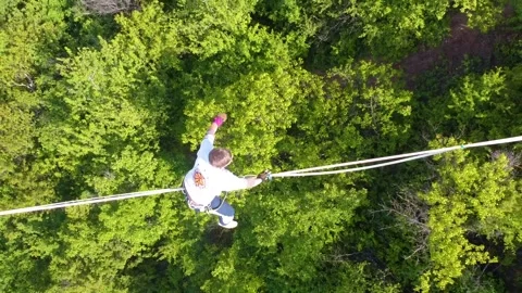 The guy on the sling is engaged in slack line at high altitude. View from above Stock Footage 131851959