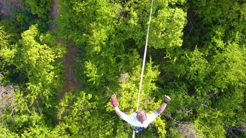 The guy on the sling is engaged in slackline at high altitude. View from above Stock Footage 131851953