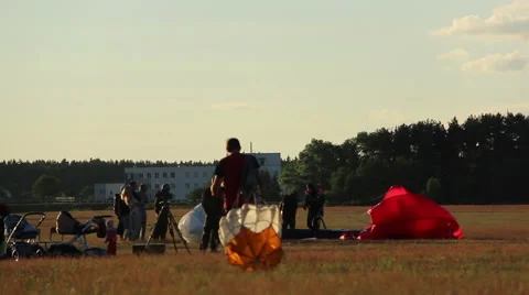 Guy with a small parachute is on the field Stock Footage 52141983