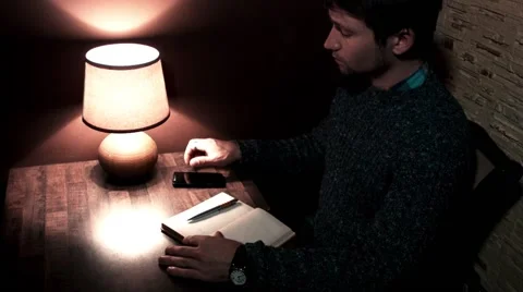 The guy with a smartphone pen writes in notebook Video stock 56250525