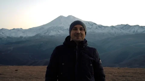 Guy smiles amidst the Mountain Ranges Stock Footage 98451077