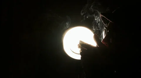 A guy smoke cigarette in front of the light 스톡 동영상 39818548