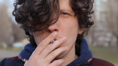 Guy smokes a cigarette, face of an attractive man Stock Footage 125911369