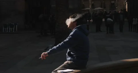 Guy Smokes A Cigarette On The Square In Barcelona Slow-Motion HD Stock Footage 131565922